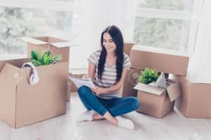 femme dans son intérieur au milieu de ses cartons de déménagement